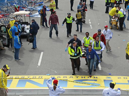 Medical workers wheel the injured across the finish line during the 2013 Boston Marathon following an explosion in Boston, Monday, April 15, 2013. Two explosions shattered the euphoria of the Boston Marathon finish line on Monday, sending authorities out on the course to carry off the injured while the stragglers were rerouted away from the smoking site of the blasts. (AP Photo/Charles Krupa)