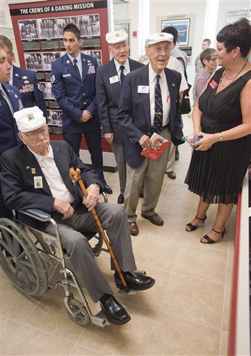 Doolittle Raiders, in white caps, left to right, Edward J. Saylor, David J. Thatcher and Richard E. Cole view the new Doolittle Raiders exhibit at Northwest Florida State College in Niceville, Fla.