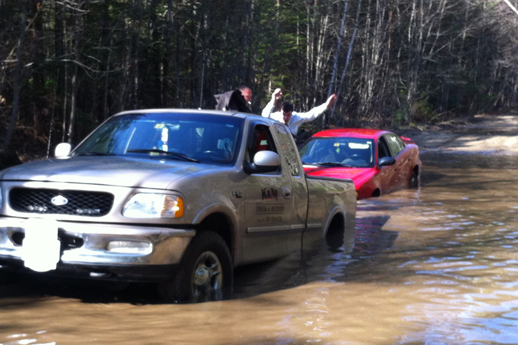 In this photo provided by Lebanon Rescue, a man who was trapped on the roof of his Pontiac Grand Am jumps into the bed of a Lebanon Rescue pickup truck.