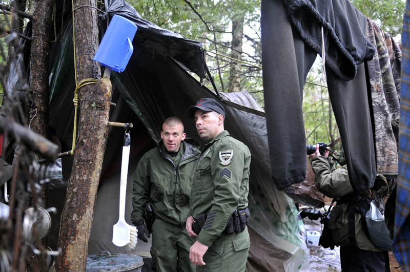 Staff photo by Andy Molloy Game Warden Sgt. Terry Hughes, right and District Warden Dave Ross inspect Christopher Knight's camp Tuesday April 9, 2013 in a remote, wooded section of Rome. Police believe Knight, who went into the woods near Belgrade in 1986, was a hermit who committed hundreds of burglaries to sustain himself.