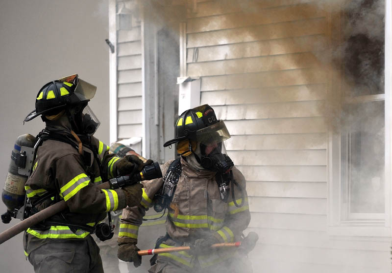 Firefighters from Waterville, Winslow and Fairfield battle a fire at 10 Maple St. in Fairfield on Tuesday.