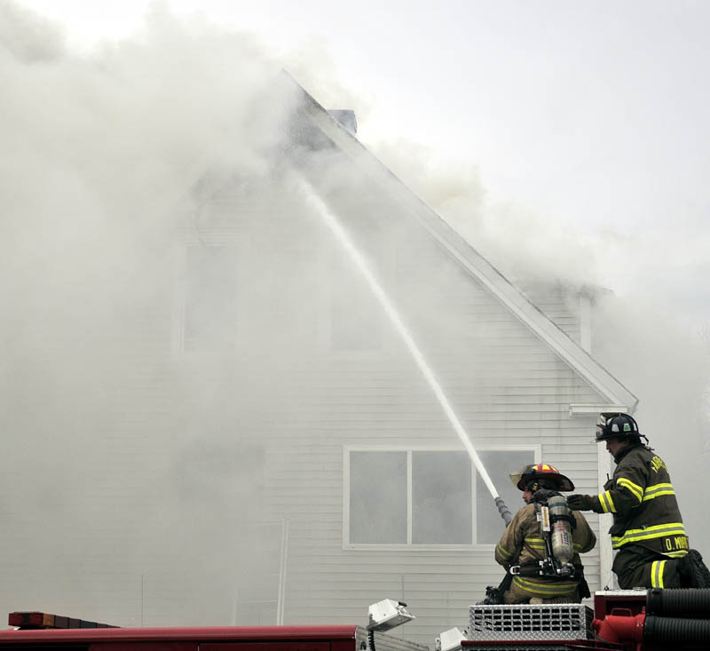 Firefighters from Waterville, Winslow and Fairfield battle a fire at 10 Maple St. in Fairfield on Tuesday.