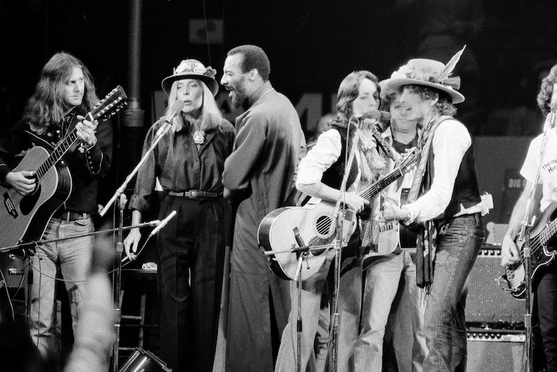 In this Dec. 1975 file photo, musicians Roger McGuinn, Joni Mitchell, Richie Havens, Joan Baez and Bob Dylan perform the finale of the The Rolling Thunder Revue, a tour headed by Dylan.  (AP Photo, File)