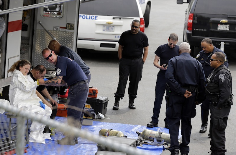 A Prince George's County, Md. firefighter, left, gets dressed in a protective suit before going into a government mail screening facility in Hyattsville, Md., Wednesday, April 17, 2013. Police swept across the U.S. Capitol complex to chase a flurry of reports of suspicious packages and envelopes Wednesday after preliminary tests indicated poisonous ricin in two letters sent to President Barack Obama and a Mississippi senator. (AP Photo/Alex Brandon)
