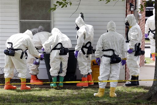 Federal agents wearing hazardous material suits inspect a trash can on Friday outside the house of Paul Kevin Curtis in Corinth, Miss. Curtis is in custody under the suspicion of sending letters covered in ricin to President Barack Obama and U.S. Sen. Roger Wicker, R-Miss.