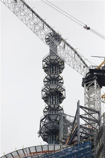 Construction cranes work on assembling the rising spire on top of One World Trade Center in New York. It is already New York's tallest building. But when the last pieces of its spire go up to the roof on Monday, the 104-floor skyscraper will be one step away from becoming the highest in the Western Hemisphere.