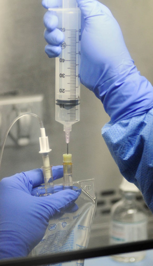 Pharmacy technician Suzanne Goddard prepares medicine in the sterile room on April 12, at Kennebec Pharmacy & Home Care in Augusta.