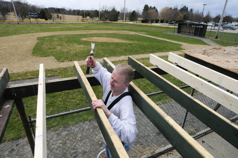 Norman Barbeau and other volunteers repair a dugout roof at Rivelli Field on Friday in Augusta. The field is used by Augusta Little League, whose season will open in two weeks, on May 4.