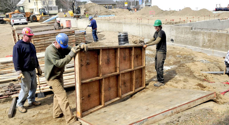 Workers build foundation walls for the new Advance Auto Parts being built on Madison Avenue in Skowhegan on Tuesday.