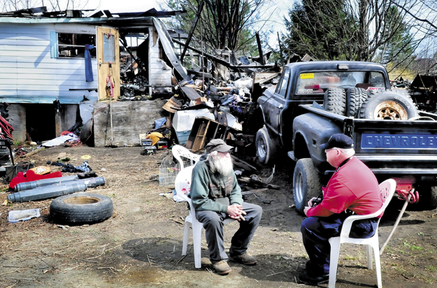 Home owner Clyde Berry, left, speaks with state Fire Marshal's Office investigator Ken MacMaster outside the ruins of Berry's home in Benton that was destroyed by fire early Monday.