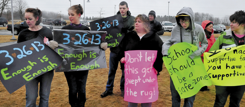 Family and friends of Kitty McGuire, a Mount View Middle School student from Troy who committed suicide last week, assembled outside the school in Thorndike to address bullying on Monday. McGuire's uncle, Timothy McGuire, center, who said he was raised as her brother, said he wants the school to admit there is a bullying problem and deal with the issue.
