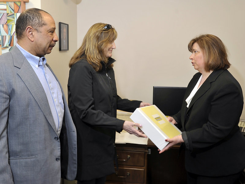 Wayne and Judi Richardson of South Portland give Crystal Canney, communications director for Sen. Angus King, petitions with more than 6,000 signatures in support of federal gun controls at King’s Portland office on Friday. The Richardsons’ daughter Darien died in 2010 after being shot by an intruder in her apartment.