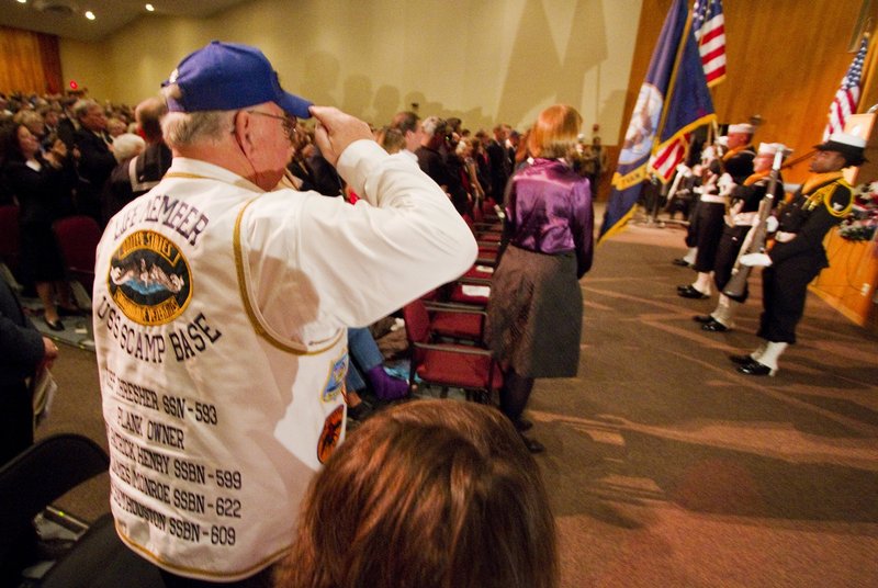 Hundreds gathering at Portsmouth High School, including former USS Thresher crew member Robert J. Miller, left, salute the flag to begin Saturday’s memorial ceremony.