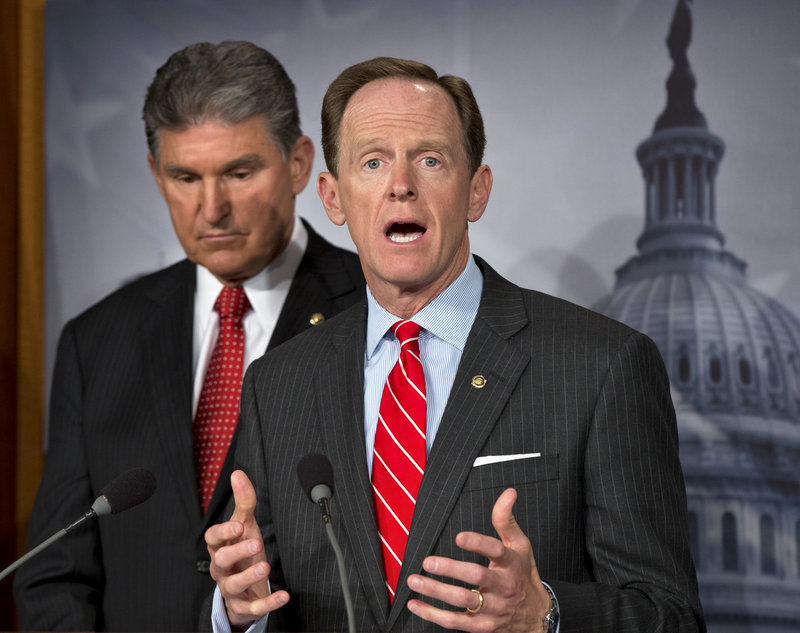 Sen. Joe Manchin, D-W.Va., left, and Sen. Patrick Toomey, R-Pa., discuss their bill which would require background checks on private sales of guns, if the buyer is not known to the seller, on Wednesday.