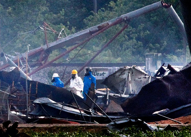 Searchers in protective suits walk through the blast zone Thursday of the fertilizer plant that exploded Wednesday night in West, Texas.