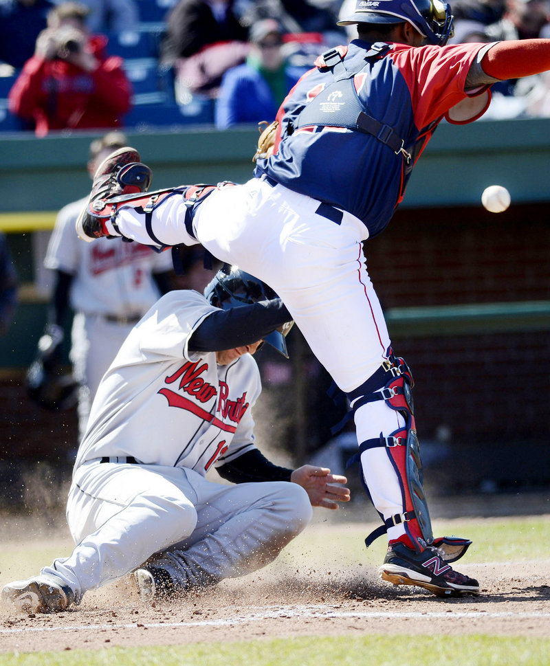 New Britain's Nate Hanson slides safely into home as Sea Dogs catcher Alberto Rosario tries to field the throw during Sunday's game at Hadlock Field. The Sea Dogs won, 8-7.