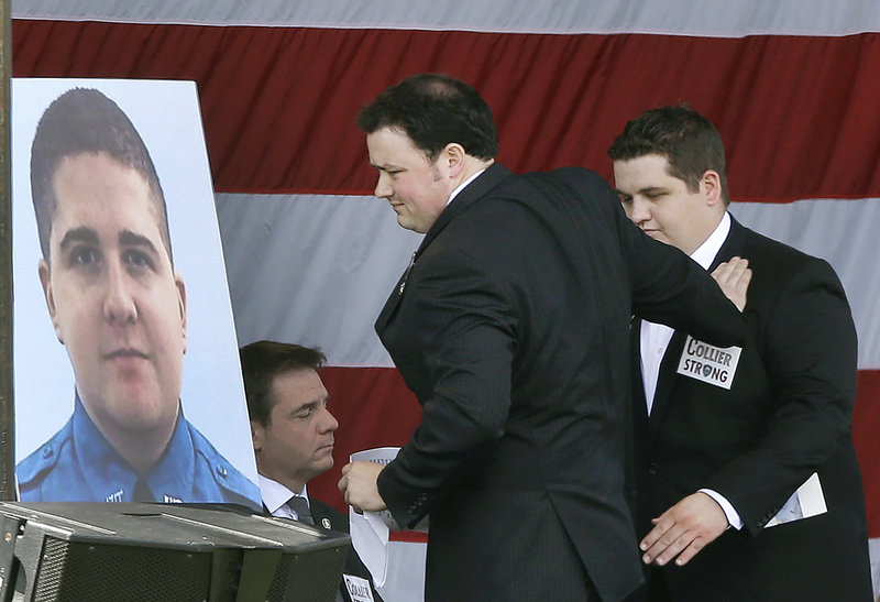 Robert Rogers, left, puts his hand on his stepbrother, Andrew Collier, after delivering the eulogy at a memorial service for slain Massachusetts Institute of Technology campus officer, Sean Collier, at MIT in Cambridge, Mass. Wednesday, April 24, 2013. Authorities say Collier was killed by the Boston Marathon bombing suspects Thursday, April 18. He had worked for the department a little more than a year. (AP Photo/Elise Amendola)