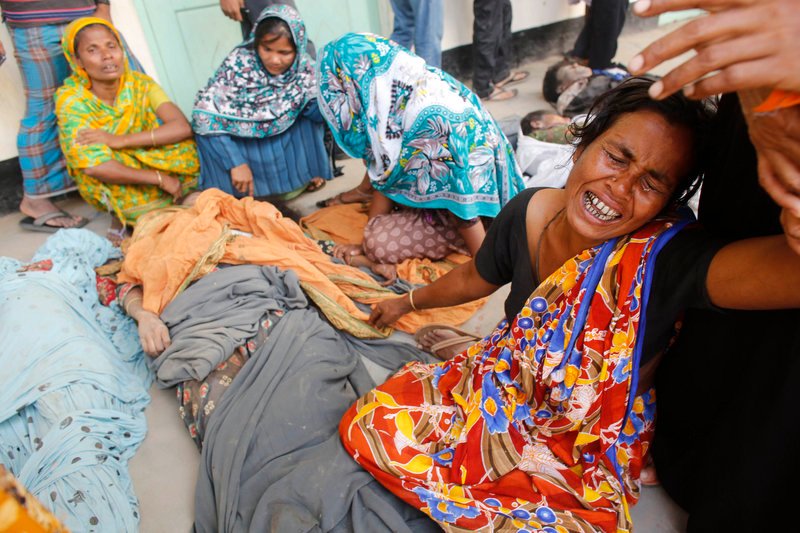 People mourn in front of the remains of their relatives who died in the collapsed Rana Plaza building in Savar, 19 miles outside Dhaka, Bangladesh, on Thursday. The number of people killed by the collapse of the building rose to 275.
