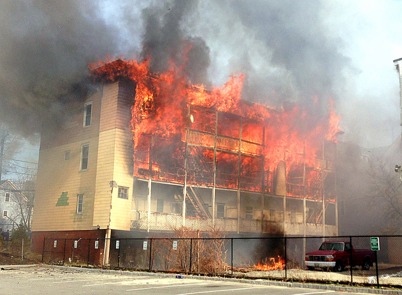 Fire consumes an apartment building Monday in Lewiston, one of three that were destroyed in a dense residential block near the downtown.