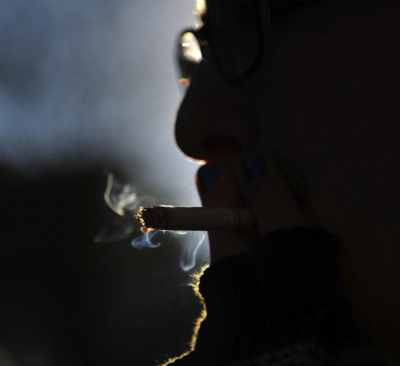 In this January 2013 file photo, Dex Robbins, 21, smokes outside the Portland Public Library on Monday afternoon, January 7, 2012. Gov. LePage has successfully vetoed a bill that would have banned smoking at Maine's public college campuses.