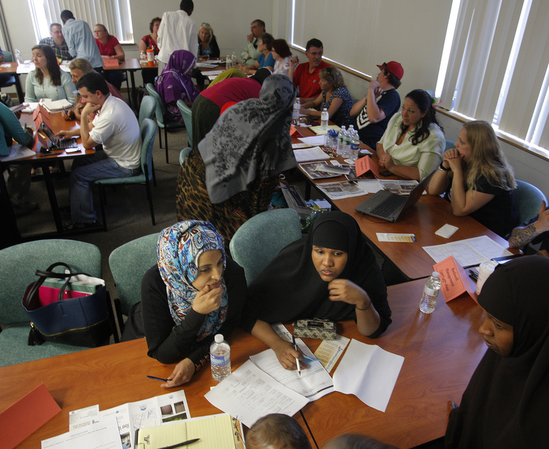 Kheyko Jama and Rukiya Muhumed fill out housing forms during a housing fair in Lewiston on Wednesday. Jama, who lived at 149 Bartlett St., and Muhumed, who lived at 114 Pierce Str., were displaced in recent fires that ravaged downtown Lewiston.