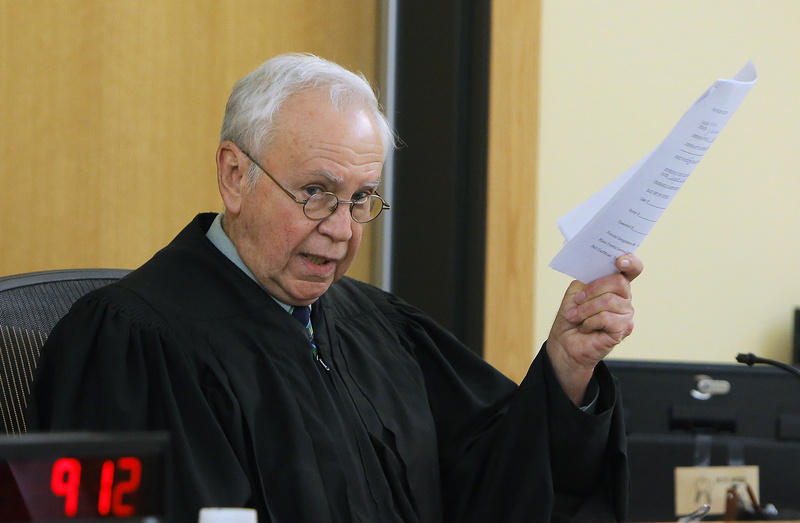Judge John Beliveau holds a copy of an affidavit from defendant Brian Morin during Moran's arraignment Monday in Lewiston District Court on three counts of arson.