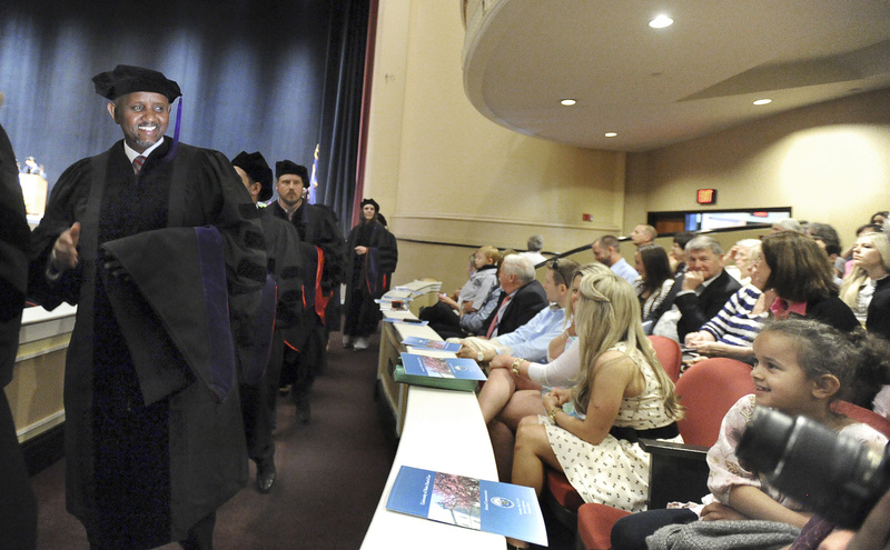 Issa Farah smiles at his daughter Bilan, 7, and other family members as he and 97 other University of Maine law students enter Merrill Auditorium in Portland Saturday for their graduation ceremony.