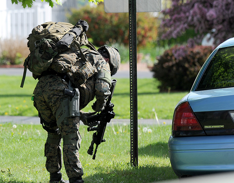 John Patriquin/Staff Photographer A member of the Maine State Police tactical unit loads his weapon as he joins dozens of state and local police officers on Hillview Avenue in Saco during Saturday’s standoff with a man identified as Charles Scontras.