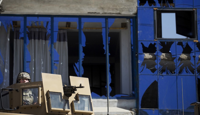 A U. S soldier secures the area where a suicide car bomber attacked a NATO convoy in Kabul, Afghanistan, Thursday, May 16, 2013. A Muslim militant group, Hizb-e-Islami, claimed responsibility for the early morning attack, killing many in the explosion and wounding tens, police and hospital officials said. The powerful explosion rattled buildings on the other side of Kabul and sent a pillar of white smoke into the sky in the city's east. (AP Photo/Anja Niedringhaus)