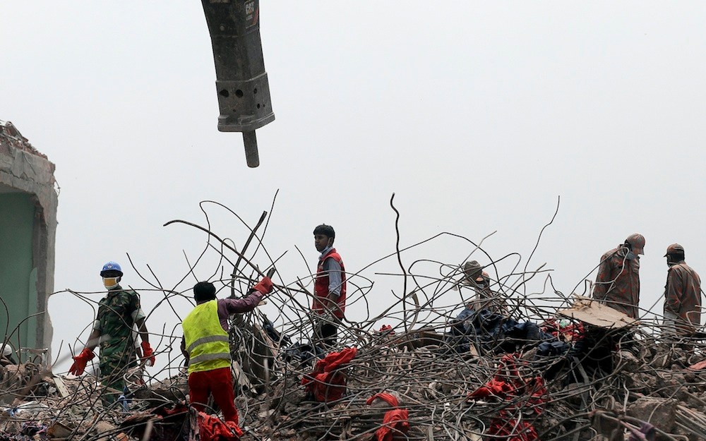 Rescuers work at the site of the eight-story Rana Plaza building that collapsed in Savar, near Dhaka, Thursday, May 9, 2013. The death toll from the collapse of the garment factory building passed 900 on Thursday even as a fire in an 11-story garment factory Wednesday night in Dhaka killed eight people, including a ruling-party politician and a top official in the country's powerful clothing manufacturers' trade group. (AP Photo/Ismail Ferdous)
