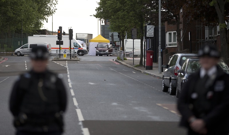Police cordon off the scene of an attack which has left one man confirmed dead and two people wounded near Woolwich barracks in London Wednesday, May, 22, 2013. Scotland Yard said officers responded to reports of an assault Wednesday afternoon in the London neighbourhood of Woolwich. London Ambulance service said one man was found dead at the scene and two other men were taken to the hospital, with one in serious condition.(AP Photo/Alastair Grant)