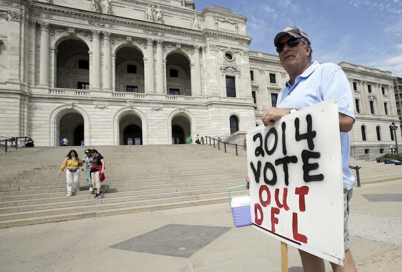 Mark Winiecki of Forest Lake, Minn., displays his opposition to Monday's passage of the gay marriage bill on the steps of the State Capitol Tuesday, May 14, 2013, in St. Paul, Minn. Gov. Mark Dayton will sign the bill, passed largely by the Democratic-Farmer-Labor (DFL) controlled Legislature, in front of the Capitol early Tuesday evening. (AP Photo/Jim Mone)