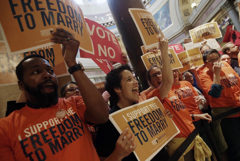 Demonstrators gather outside the Minnesota House chamber to greet lawmakers as they arrive to take up the gay marriage bill at the State Capitol, Thursday, May 9, 2013 in St. Paul, Minn. (AP Photo/Jim Mone)