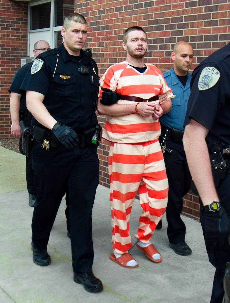 Officers escort murder suspect Kyle Flack to the Franklin County Courthouse from the Franklin Detention Center, Friday, May 10, 2013, in Ottawa, Kan. Flack was charged Friday in the deaths of a woman and two men whose bodies were found at an eastern Kansas farm home earlier this week, according to a criminal complaint. (AP Photo/The Kansas City Star, Allison Long)
