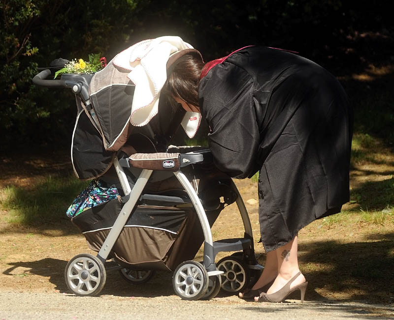 University of Maine at Farmington graduate Christina Carrier has a moment with her 2-month old son, Hunter, before commencement ceremonies in Farmington on Saturday.