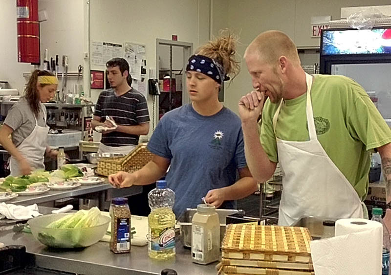 Sasha Letourneau, center, a senior at Lawrence High School, cooks a meal with the help of Steve Yakimchick, right, a chef at the Pointe Afta restaurant. Letourneau was one of four finalists in an "Amazing Race" style scholarship competition sponsored by Taconnet Federal Credit Union.