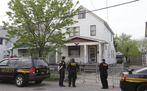 Sheriff deputies stand outside the house on Seymour Avenue in Cleveland where three women who vanished a decade ago were found.
