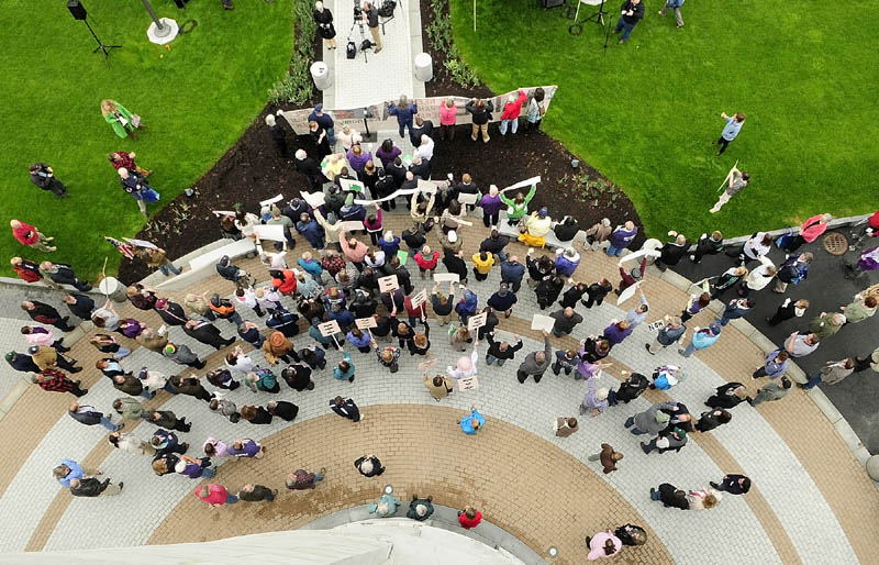 People chant at the start of a lunchtime rally to protest Gov. Paul LePage's budget plan on Wednesday, on the plaza outside west entrance of the State House in Augusta. Speakers included Hallowell Mayor Charlotte Warren; Leslie Manning, a board member of the Maine Council of Churches; and Ron Green, president of the Bangor Professional Firefighters. The governor's office is located near the rally site.