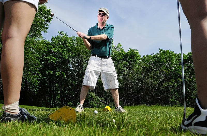 St. Michael School teacher John "Pete" Hickey gives seventh-graders some pointers on the driving range on Friday at Western View Golf Club in Augusta. Hickey will be retiring this year after the teaching for 37 years at the parochial school, on the corner of Western Avenue and Sewall Street in Augusta. For the last 19 years, he's organized an end-of-the-year golf outing for the seventh graders. Hickey said he will be teaching social studies for a day a week next year.