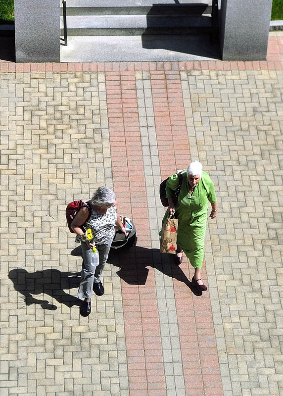 A pair of women walk across the plaza between State House and Burton M. Cross State Office Building on Wednesday in Augusta. The weather forecast through the weekend calls for a chance of clouds and showers.
