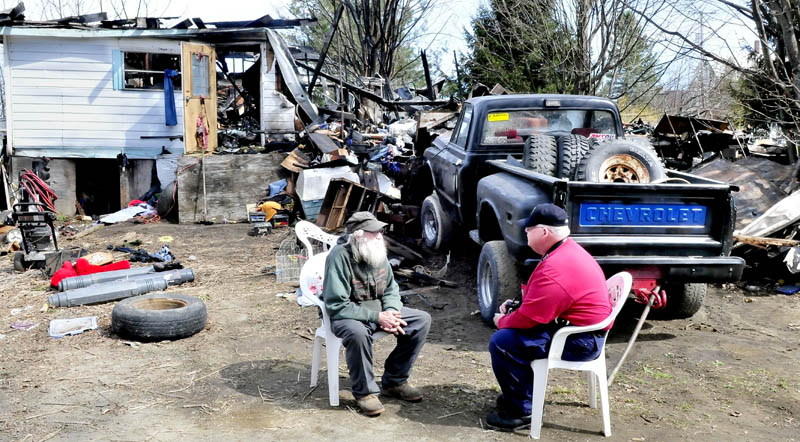 Home owner Clyde Berry, left, speaks with state Fire Marshall's Office investigator Ken MacMaster outside the ruins of his home in Benton Monday.