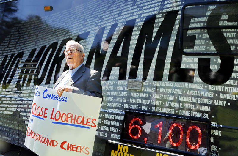 The Rev. Jim Gill holds a placard before reading the names of shooting victims at the No More Names gun-control rally Monday in Augusta.