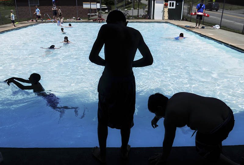 Children take a plunge into the Calumet Playground pool Wednesday in Augusta on the second day of its summer opening. All three public pools in Augusta are scheduled to open this week and offer swimming between Tuesday and Saturday, 11 a.m. to 5 p.m., according to lifeguards.
