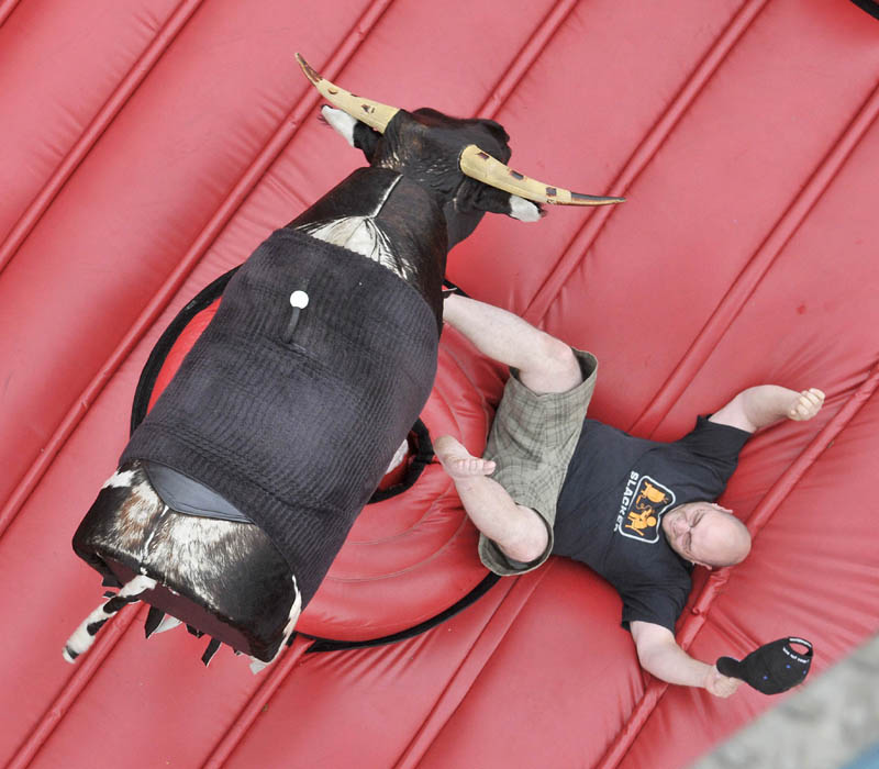 Dan Cahoon, of Oakland, gets thrown from the mechanical bull at the Water Street carnival during the Fairfield Days Community Festival on Saturday.