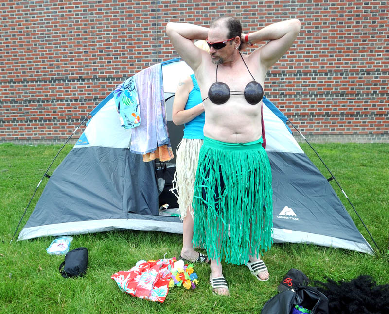 Irish Griffith, left, helps B.J. Bernier, both of Kaplan University, dress up for an impromptu hula dance at Colby College in Waterville on Saturday, after completing the second leg of the American Lung Association's Trek Across Maine cycling event.