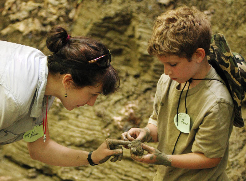 Nicole Rhodes, left, and Rocco Landry, 8 of Lewiston, take a closer look at clay they found along the banks of a stream in the Small-Burnham Conservation Area on Tuesday in Litchfield.