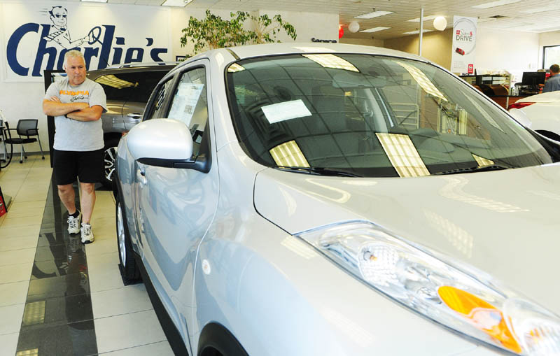 Dana Timberlake looks over a Nissan on Friday at Charlie's Motor Mall in Augusta. Automotive sales, which account for about a third of the area's taxable sales, are leading a surge in the local economy, according to business people.