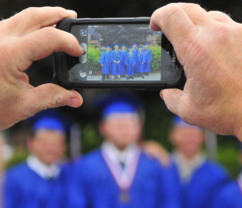 Graduating boys pose for a group shot before Messalonskee graduation on Thursday at the Augusta Civic Center.