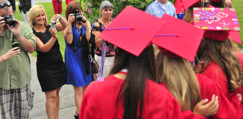 Graduating girls pose for a group shot before Messalonskee graduation on Thursday at the Augusta Civic Center.