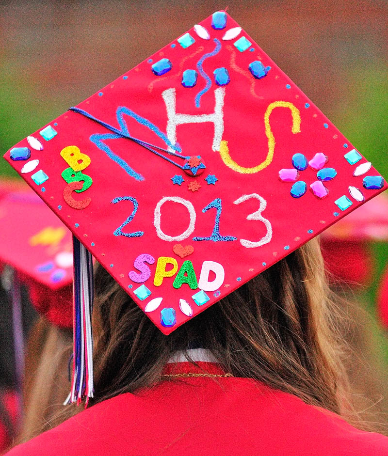 Kaitlyn Bradley waits to march wearing a decorated mortar board before Messalonskee graduation on Thursday at the Augusta Civic Center.